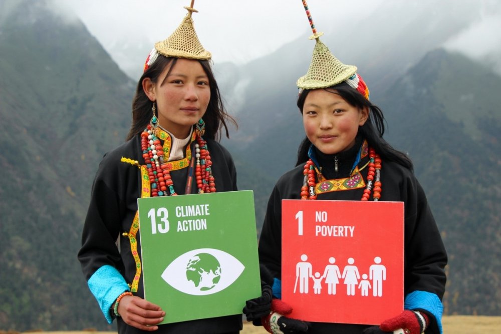 Jeunes femmes asiatiques en costume traditionnel présentant 2 logos des ODD